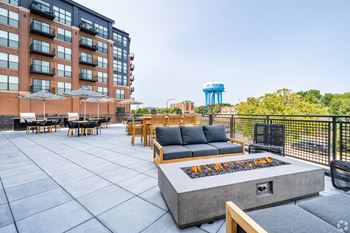 A patio with a fire pit and seating area.